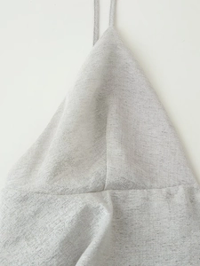 Macro shot of silver metallic glitter fabric and halter neck detail of the summer dress
