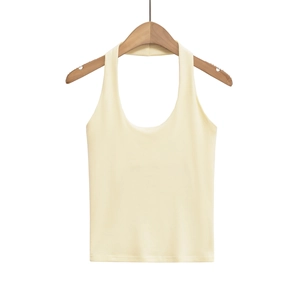 Detail of cream yellow halter top in ribbed knit fabric hanging on wooden hanger