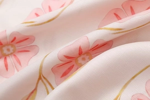 Makroaufnahme von atmungsaktivem Leinenstoff mit süßem rosa Blumendruck am Kleid