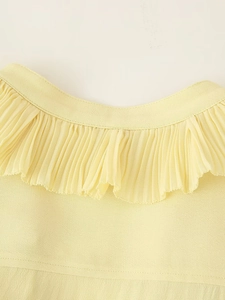 Macro detail of fine pleated light yellow fabric showing high-quality stitching and texture