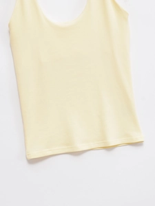 Close-up of the light yellow ribbed knit fabric texture and high-quality hem stitching