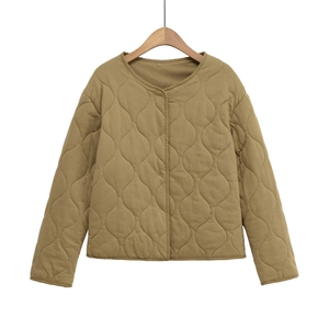Détail d'un motif matelassé ondulé sur une veste bouffante à col rond ample de couleur kaki