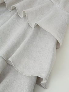 Detail of silver metallic fabric with shimmering ruffles on a mini summer dress