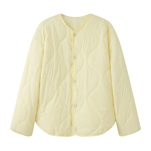 Detailed view of light yellow quilted jacket with wavy stitching and button-down front