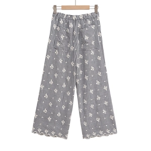 Détail du pantalon taille haute à carreaux vichy avec broderie florale et bord dentelle