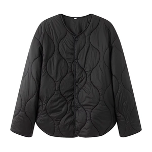 Detail view of black quilted jacket featuring wave stitching pattern and snap buttons