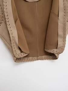 Detailed close-up of brown faux suede vest showing braided stitching and interior seams
