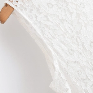 Gros plan détaillé du col en dentelle florale blanche avec motif ajouré au crochet