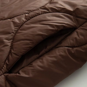 Detailed view of the diamond-quilted jacket side pocket and smooth fabric texture