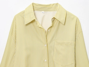 Detail of yellow and white vertical striped shirt showing collar tag and front pocket