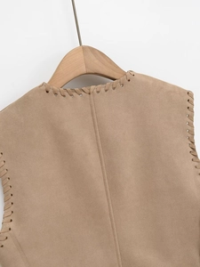 Detail of camel suede vest showing intricate whipstitch neckline and shoulder texture