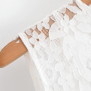 Détail du motif de dentelle blanche délicate et de la broderie florale sur la robe d'été