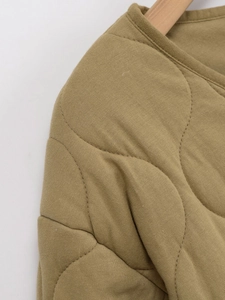 Détail de l'encolure ronde et des surpiqûres ondulées sur l'épaule de la veste kaki