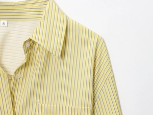 Close-up of yellow striped poplin shirt with white buttons and small classic collar detail