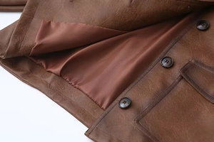 Dettaglio della giacca in pelle PU marrone con bottoni vintage e fodera interna liscia