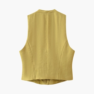 Vista macro del retro del gilet giallo senape con trama in lino e cuciture sartoriali