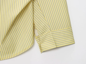 Detailed close-up of yellow and white vertical striped fabric texture and sleeve stitching