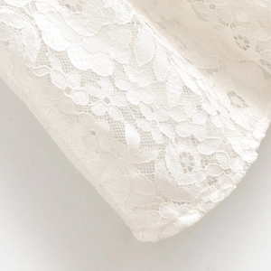 Gros plan sur un tissu en dentelle blanche avec motifs floraux et broderies fines