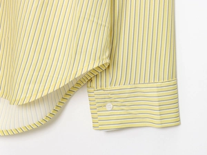 Detailed close-up of vertical striped poplin shirt with buttoned cuffs and curved hem