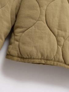 Détail du motif matelassé oignon et de la bordure sur la veste matelassée kaki