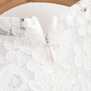Détail de la fermeture éclair cachée sur une robe en dentelle blanche à fleurs