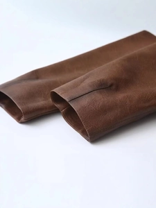 Dettaglio della giacca biker in pelle PU marrone scuro con finitura vintage strutturata