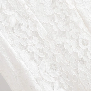 Détail de la broderie en dentelle florale blanche d'une robe d'été sans manches en A