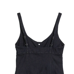 Detail eines dunkelblauen Jeanskleids mit verstellbaren Metallschnallen und Prinzessnähten