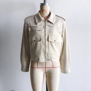 Detail of beige faux suede jacket showing flap pockets and metallic zipper hardware