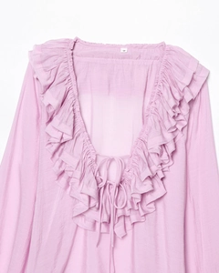 Close-up of ruffled deep V-neckline and tie detail on lavender chiffon blouse