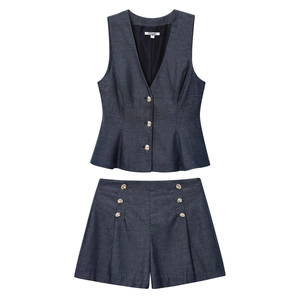 Detail of navy blue linen vest and high-waist shorts set with golden metal buttons