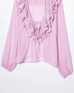 Detailed view of lilac V-neck blouse with tiered ruffles and delicate front tie strings