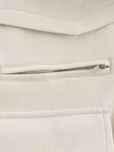 Detailed macro view of the zipper pocket and fine stitching on the suede jacket