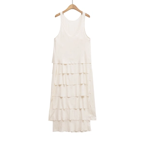 Detail view of the tiered skirt layers on a white sleeveless summer maxi dress