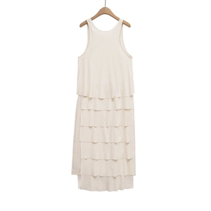 Detailed view of cream-colored sleeveless dress featuring multi-layered ruffled tiers