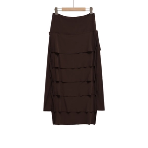 Detailed view of dark brown tiered midi skirt featuring layered fabric and side zipper