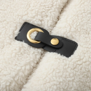 Detail shot of sherpa fleece fabric texture with black leather buckle and gold metal hardware