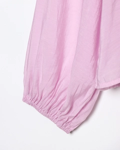 Detail of pink blouse showing ruffle elastic cuffs and lightweight textured fabric