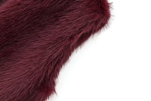 Détail en gros plan de la fausse fourrure bordeaux douce avec fini brillant sur gilet