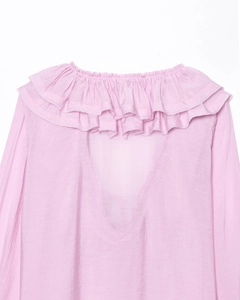 Detail of pink chiffon blouse showing layered ruffle neckline and delicate V-neck design