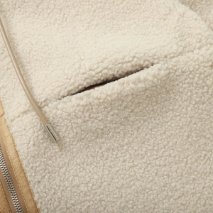 Détail de la veste en polaire beige avec cordon en cuir et embout métallique argenté