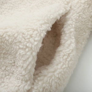 Close-up of off-white sherpa fleece texture and pocket stitching on this warm winter coat