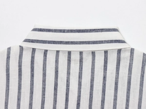 Dettaglio del colletto a righe bianche e blu con trama in cotone e lino naturale