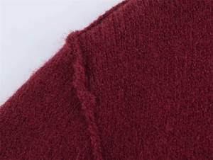 Detailansicht von burgunderrotem Mohair-Strick mit weicher Textur und feiner Nahtverarbeitung