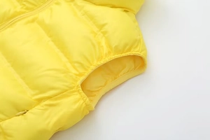 Détail de la veste matelassée jaune montrant l'emmanchure élastique et la couture