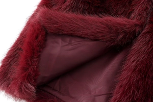 Détail du gilet en fausse fourrure bordeaux avec texture douce et doublure satinée