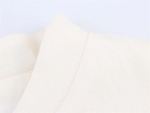 Detail of premium ivory woven fabric showing precise stitching on the jacket collar