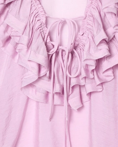 Detail showing V-neck with lace-up tie and layered ruffles on light pink blouse