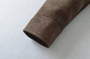 Detailed close-up of double stitching on dark brown suede motorcycle jacket cuffs