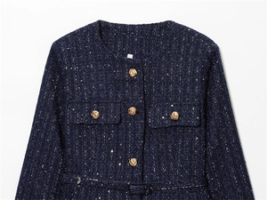 Detailed view of dark blue tweed jacket with sparkling weave and gold textured buttons